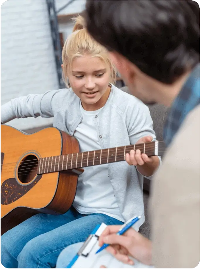 Tutor Instructing to Play Guitar
